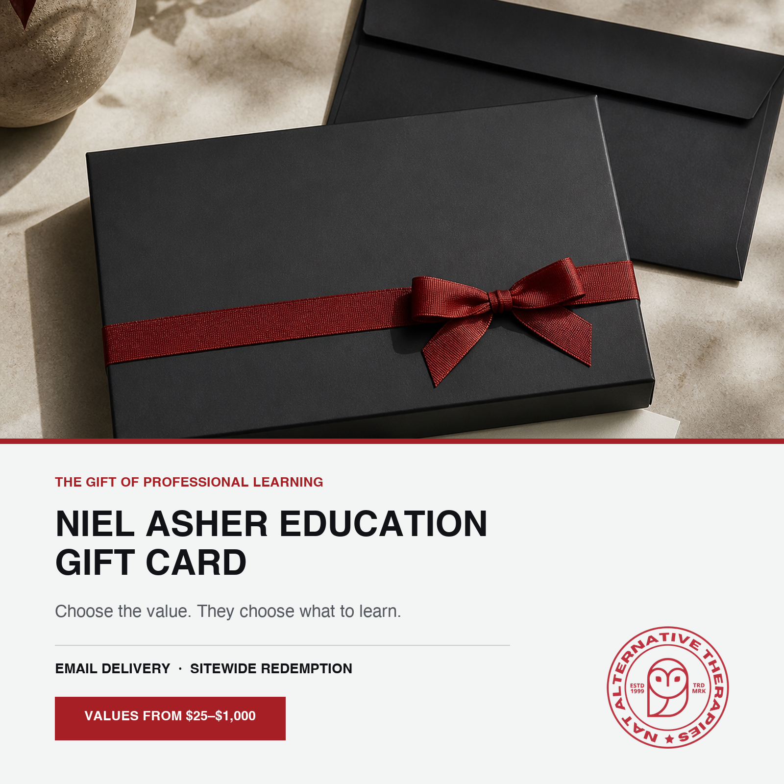 A black gift box with a dark red ribbon and bow, with a white promotional card below reading 'NIEL ASHER EDUCATION GIFT CARD' and showing the Alternative Learning Partners logo.